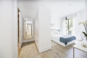 Dormitorio principal con baño de la vivienda piloto de la promoción Ramón y Cajal de AEDAS Homes en Sevilla.